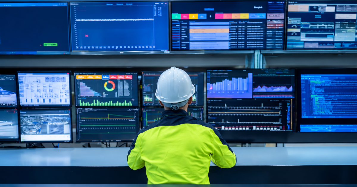 Industrial control room with plant operators monitoring real-time equipment status on dashboard screens
